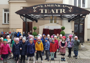 Dzieci pozują przed wejściem do teatru Kamienica